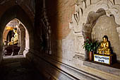 Bagan Myanmar. Htilominlo temple. Niches of the vaulted corridor of the ground floor with stone Buddha images. 